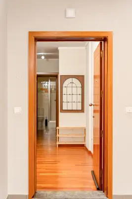 an open door to a hallway with white walls and wood floors at New Santa Cruz Airport & Downtown Apartment in Santa Cruz