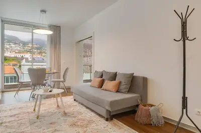 a living room with a couch and a table at Plaza city center- Balcony amazing views in Funchal
