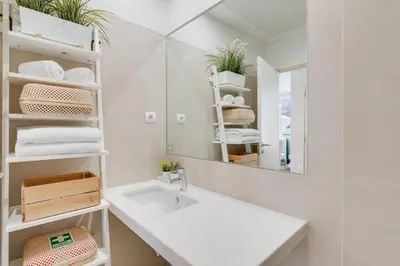 a white bathroom with a sink and a mirror at Plaza city center- Balcony amazing views in Funchal