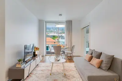 a living room with a couch and a table at Plaza city center- Balcony amazing views in Funchal