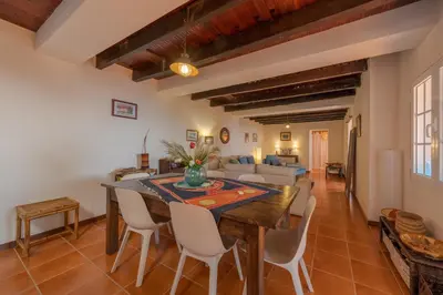 a kitchen and living room with a table and chairs at Villa Flora by Holiday Rental Madeira in Estreito da Calheta