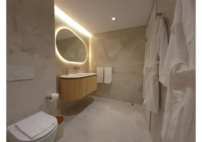 a bathroom with a sink and a toilet and a mirror at Shell Living - Marina in Funchal