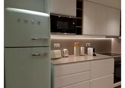a kitchen with white cabinets and a refrigerator at Shell Living - Marina in Funchal