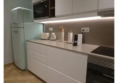 a kitchen with white cabinets and a refrigerator at Shell Living - Marina in Funchal