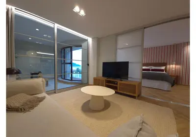 a living room with a couch and a bed and a television at Shell Living - Marina in Funchal