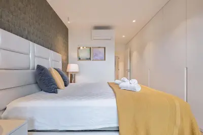 a bedroom with a large white bed with towels on it at Apartamento Moderno T2 com Pátios e Acesso a Piscina in Funchal