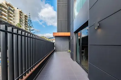 an empty corridor of a building with a balcony at Apartamento Moderno T2 com Pátios e Acesso a Piscina in Funchal