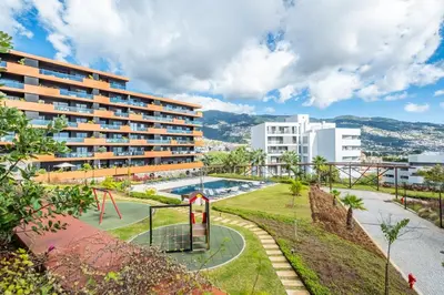 an apartment building with a pool and a playground at Apartamento Moderno T2 com Pátios e Acesso a Piscina in Funchal