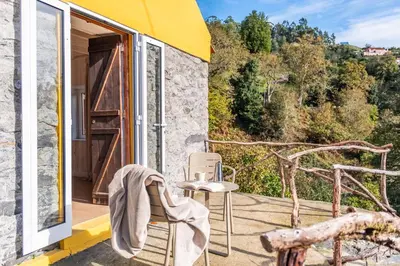 a room with a table and chairs on a balcony at Apple Tree House in Santa Cruz