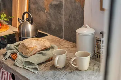 a table with two cups of coffee and a loaf of bread at Apple Tree House in Santa Cruz