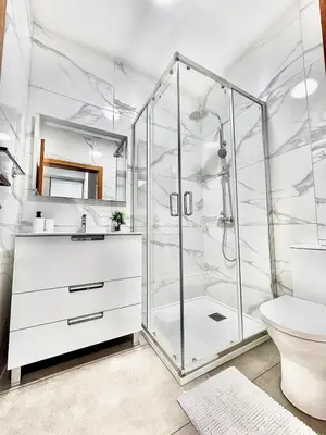 a white bathroom with a shower and a sink at Adega Do Avô, Madeira Island in Ponta Delgada