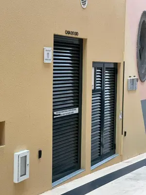 two black garage doors on the side of a building at Old Town Charm Apartment Funchal in Funchal