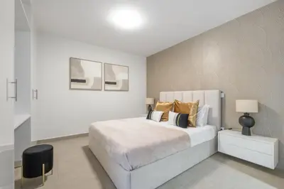 a white bedroom with a large white bed with gold pillows at Sunflower Gem by Homie in Caniço