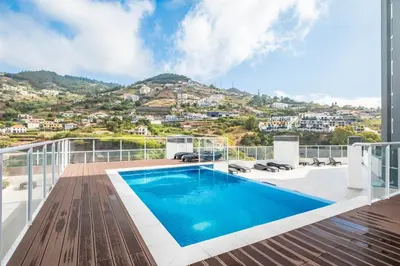a swimming pool on the balcony of a house at Sunflower Gem by Homie in Caniço