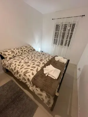a bed in a white room with a window at Latin House in Funchal