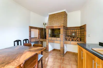 a kitchen with a table and a stove in a room at Casa da Georgina by GALMI in Arco da Calheta