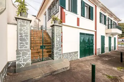a house with green doors and a fence at Casa da Georgina by GALMI in Arco da Calheta