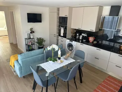 a kitchen and living room with a table and a blue couch at Refugio da Ponta do Sol 2 - Madeira Inn Group in Ponta do Sol