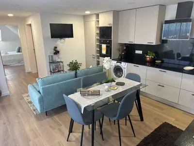 a kitchen and living room with a table and a blue couch at Refugio da Ponta do Sol 2 - Madeira Inn Group in Ponta do Sol