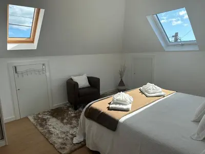a white bedroom with a bed and a chair at Refugio da Ponta do Sol 2 - Madeira Inn Group in Ponta do Sol