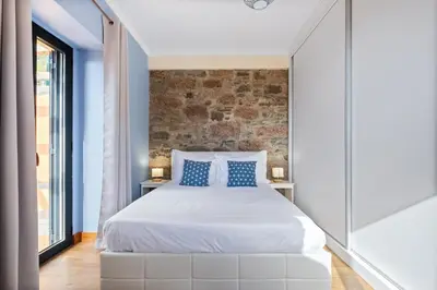 a bedroom with a large bed with a brick wall at Quinta do Checa by Homie in Quinta Grande