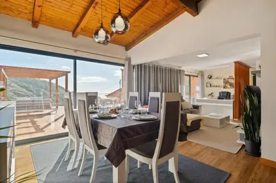 a dining room and living room with a table and chairs at Quinta do Checa by Homie in Quinta Grande