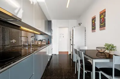 a kitchen with a table and a refrigerator at Ocean Vista- T2 Funchal in Bicas