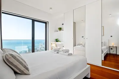 a bedroom with a large white bed with a large window at Ocean Vista- T2 Funchal in Bicas