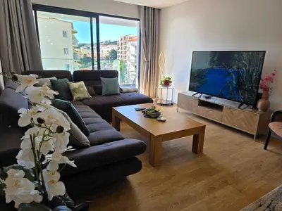 a living room with a couch and a flat screen tv at Glendeira Lux Apartment in Caniço