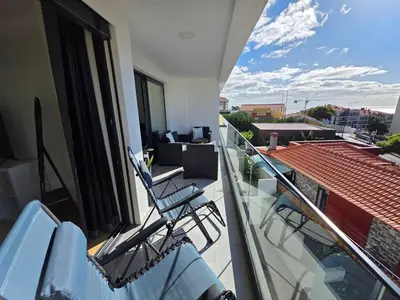a balcony with chairs and a view of a roof at Glendeira Lux Apartment in Caniço