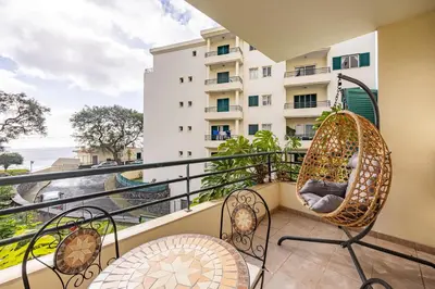 a balcony with chairs and a view of the ocean at Ocean Life by YOUR KEY MADEIRA in Caniço