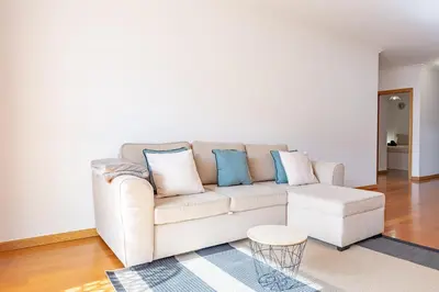 a living room with a white couch and blue pillows at Ocean Life by YOUR KEY MADEIRA in Caniço