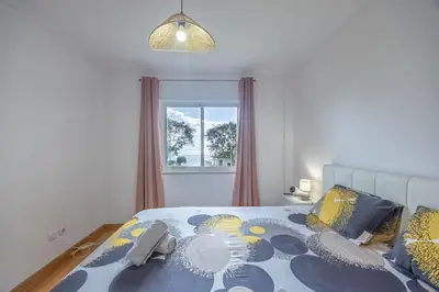 a bedroom with a bed with blue and yellow pillows at Ocean Life by YOUR KEY MADEIRA in Caniço