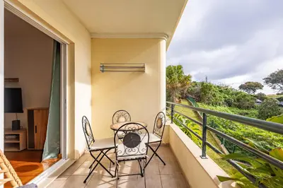 a balcony with two chairs and a table at Ocean Life by YOUR KEY MADEIRA in Caniço