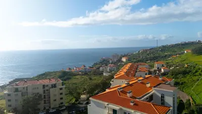 a group of buildings on a hill next to the ocean at Ocean Life by YOUR KEY MADEIRA in Caniço