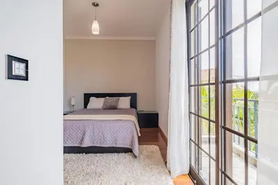 a bedroom with a bed and a large window at Country Escape in Ribeira Brava