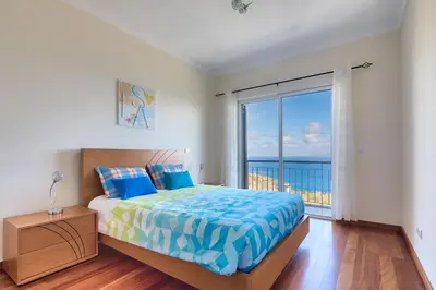 a bedroom with a bed with a view of the ocean at Villa Araujo Da Costa by HR Madeira in Caniço