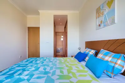 a bedroom with a large bed with blue pillows at Villa Araujo Da Costa by HR Madeira in Caniço