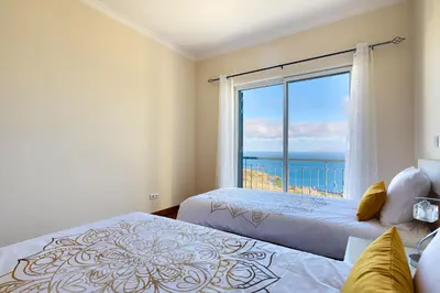 a bedroom with two beds and a large window at Villa Araujo Da Costa by HR Madeira in Caniço