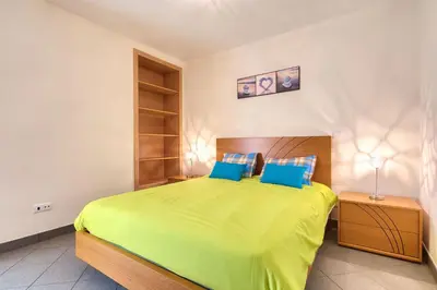 a bedroom with a large green bed with blue pillows at Villa Araujo Da Costa by HR Madeira in Caniço