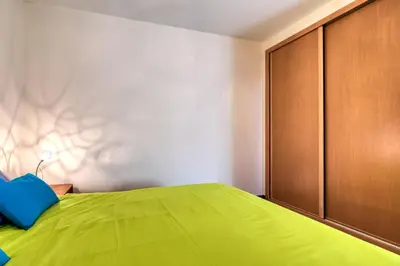 a bedroom with a green bed and a wooden cabinet at Villa Araujo Da Costa by HR Madeira in Caniço