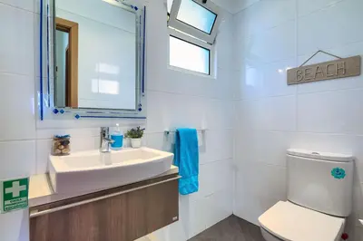 a bathroom with a sink and a toilet and a mirror at Villa Araujo Da Costa by HR Madeira in Caniço