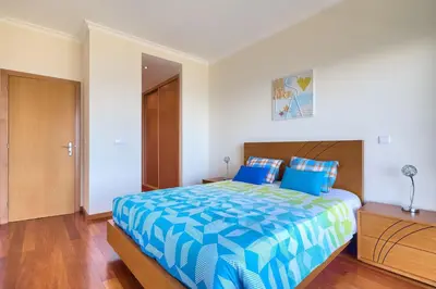 a bedroom with a large bed with a blue comforter at Villa Araujo Da Costa by HR Madeira in Caniço