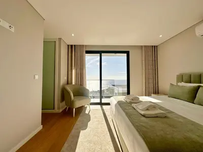 a bedroom with a bed and a chair and a window at Casa do Faial By Madeira Atlantic Escape in Funchal