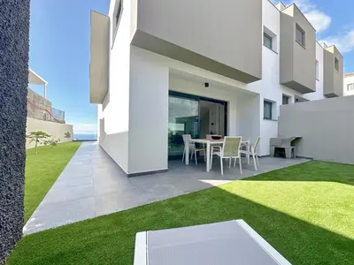 a white house with a patio and grass at Casa do Faial By Madeira Atlantic Escape in Funchal