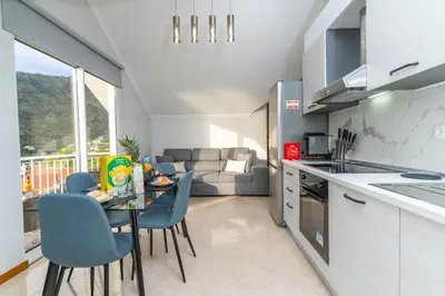 a kitchen and living room with a table and chairs at Vanda House com 2 Quartos Vista Mar e montanha no centro da Ilha in Tábua