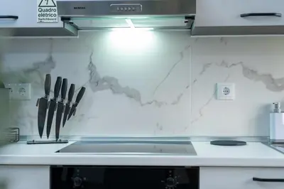 a kitchen counter with knives on a wall at Vanda House com 2 Quartos Vista Mar e montanha no centro da Ilha in Tábua