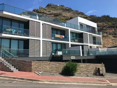 an apartment building with a hill in the background at Apto Vista Baía Machico by Susys Holidays in Machico