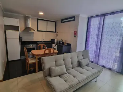 a living room with a couch and a kitchen at Apto Vista Baía Machico by Susys Holidays in Machico