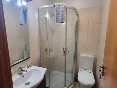 a bathroom with a shower and a toilet and a sink at Apto Vista Baía Machico by Susys Holidays in Machico